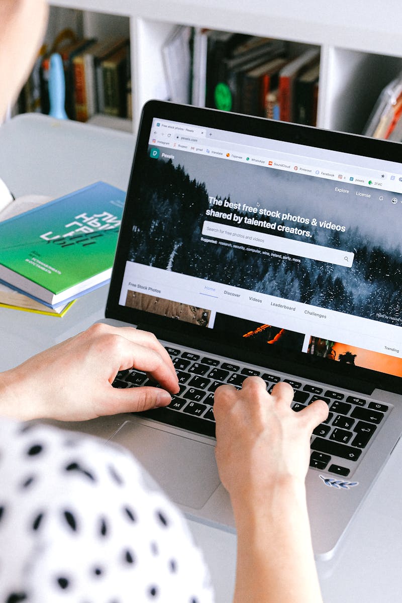 A woman using a laptop at home, browsing stock photos for creative projects.